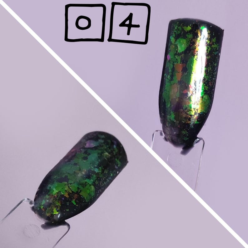 Puede incluir: Dos muestras de esmalte de u&ntilde;as en palitos de pl&aacute;stico transparente, cada una con una base negra cubierta de escamas iridiscentes verdes, moradas y doradas. La parte superior de la imagen muestra el texto 0 4 dentro de dos cuadrados.