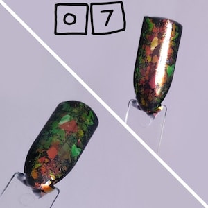 Puede incluir: Dos muestras de esmalte de u&ntilde;as en palitos de pl&aacute;stico transparente etiquetados con el n&uacute;mero 07. Las muestras presentan una base negra cubierta con escamas iridiscentes multicolores en tonos verde, naranja y rojo con acabado brillante.