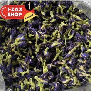 Pode incluir: Uma imagem de close-up de flores secas de ervilha borboleta azul. As flores são de um azul profundo com caules verdes e estão dispostas em uma pilha. As flores são usadas para fazer chá e outras bebidas.