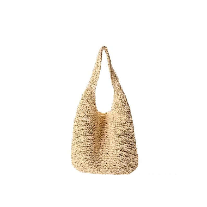 May include: A beige, woven tote bag with a shoulder strap. The bag is made of a natural fibre material and has a large, open interior. The bag is designed with a rounded bottom and a wide opening.