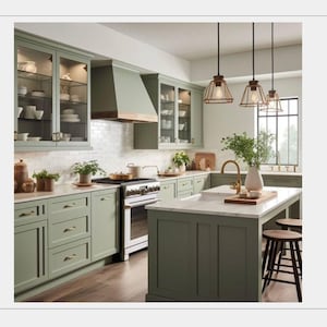 May include: A modern kitchen with sage green cabinets, a white marble countertop, and a large island. The kitchen features a white tile backsplash, a wooden range hood, and pendant lights. The room is well-lit and has a warm, inviting atmosphere.
