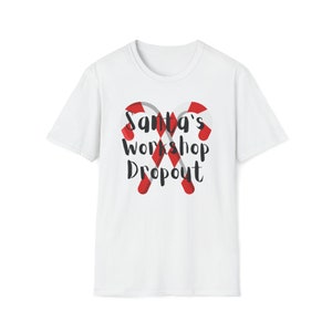 May include: White t-shirt featuring a red and white candy cane design and the text "Santa's Workshop Dropout".