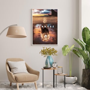 May include: Framed art print featuring a lion cub and its reflection, with the word "MINDSET" across the image. The artwork has a sunset backdrop with a desert landscape. The print is displayed on a white wall.