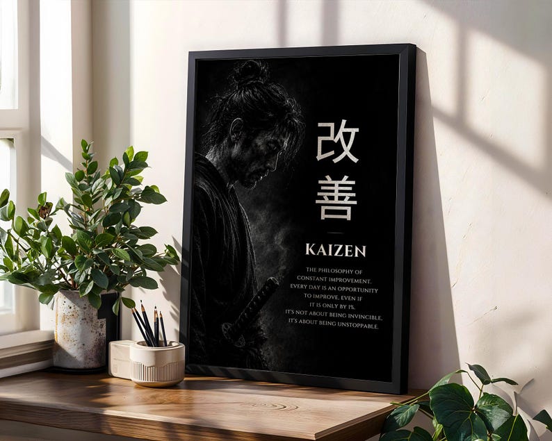 Op de afbeelding: Een zwart ingelijste kunstprint met een monochrome illustratie van een samoerai in profiel. De tekst bevat de Japanse kanji voor Kaizen, het woord Kaizen en een alinea die de filosofie van constante verbetering uitlegt.