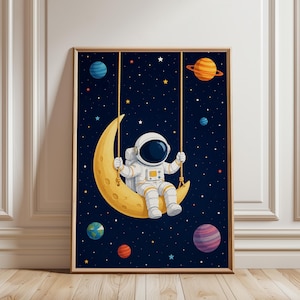 Könnte beinhalten: Ein gerahmtes Wandbild, das einen Astronauten in einem weißen Raumanzug zeigt, der auf einer gelben Mondsichelschaukel sitzt. Der Hintergrund ist ein dunkelblauer Sternenhimmel mit verschiedenen bunten Planeten, darunter ein orangefarbener Ringplanet.
