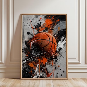 Könnte beinhalten: Ein rechteckiges gerahmtes Wandbild mit einem Basketball, der vor einem abstrakten Hintergrund aus schwarzen, weißen und orangefarbenen Farbspritzern, Tropfen und Pinselstrichen zentriert ist und eine dynamische Komposition bildet.