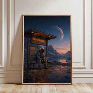 May include: A framed wall art print depicting an astronaut in a white spacesuit sitting on a bench at a bus stop on a rocky planet. An orange sign reads Next Shuttle: Shuttle: Delayed. A large moon hangs in the dark sky over distant mountains.
