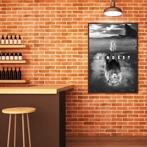 May include: Black and white framed print featuring a lion and its reflection in water. The word "MINDSET" is printed in white at the bottom of the image. The print is displayed on a brick wall, with a bar and stools in the foreground.