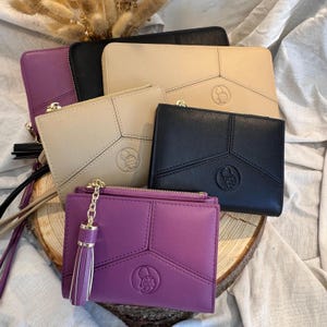 Könnte beinhalten: Vier verschiedene farbige Geldbörsen mit geometrischem Design und einem kleinen geprägten Logo. Die Geldbörsen sind beige, lila, schwarz und braun.