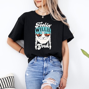 a woman wearing a black t - shirt that says feelin' Willie good