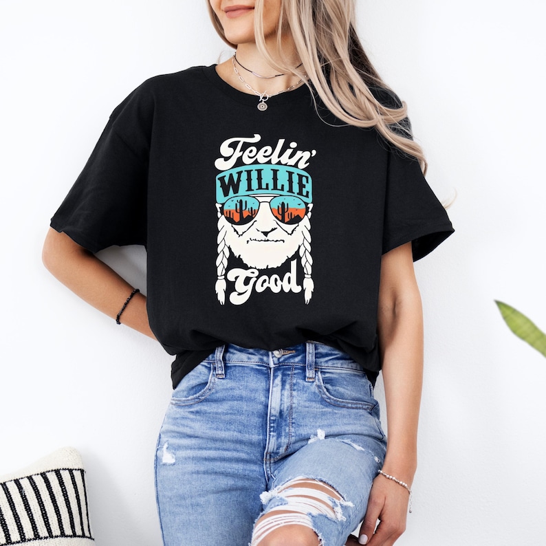 a woman wearing a black t - shirt that says feelin' Willie good