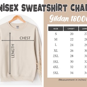 May include: A beige crewneck sweatshirt on a wooden hanger with a size chart titled UNISEX SWEATSHIRT CHART Gildan 18000. The chart lists sizes S through 5XL with corresponding chest and length measurements in inches, ranging from 20 to 34 inches.