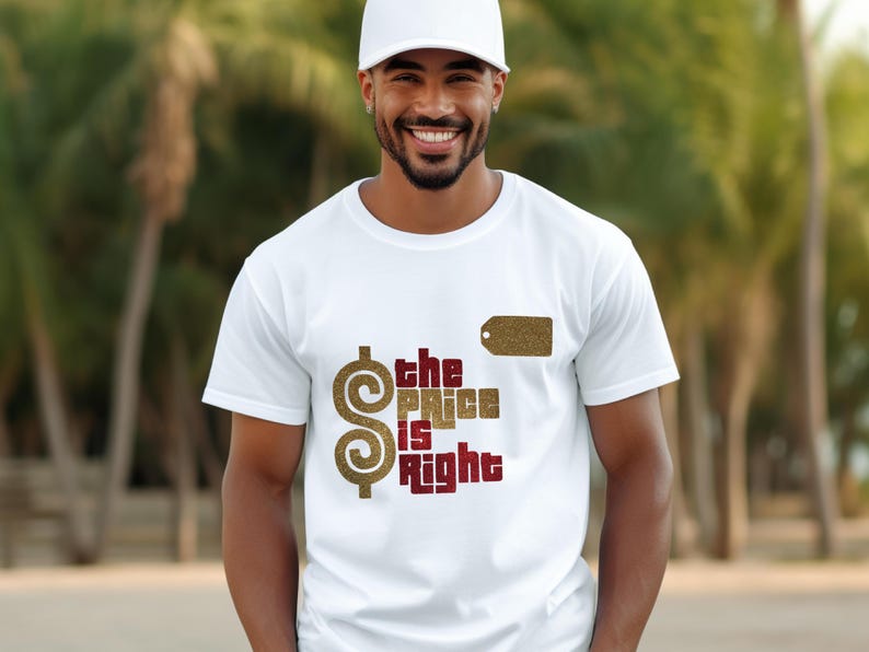 May include: A white short-sleeved t-shirt featuring a large gold glitter dollar sign and the text "the PRICE is Right" in a combination of gold glitter and dark red lettering, along with a small gold glitter rectangular tag graphic.