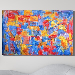 Puede incluir: Pintura abstracta con trazos audaces de pintura azul, roja y amarilla. La pintura está enmarcada y colgada en una pared blanca.
