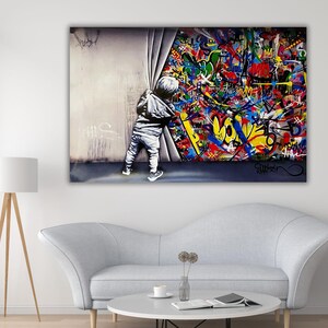 Op de afbeelding: Een rechthoekige wandkunstprint met een grijstinten kind in een hoodie die een grijs gordijn opzij trekt om een levendige, chaotische explosie van kleurrijke graffitikunst te onthullen. De graffiti bevat heldere rode, gele, blauwe en groene tinten met diverse abstracte vormen.