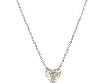 Puede incluir: Un collar de cadena de plata con un colgante de diamante en forma de corazón.