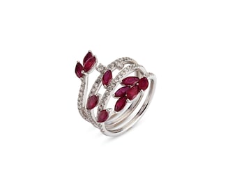 Könnte beinhalten: Ein Ring aus Weißgold mit einem Spiraldesign, das mit roten Rubin- und weißen Diamantensteinen besetzt ist.