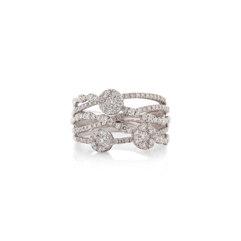 K&ouml;nnte beinhalten: Ein mehrschichtiger Silberring mit mehreren B&auml;ndern und kreisf&ouml;rmigen Diamantclustern. Der Ring hat ein einzigartiges Design mit ineinander verschlungenen B&auml;ndern, das einen modernen und eleganten Look erzeugt. Der Ring ist vor wei&szlig;em Hintergrund.