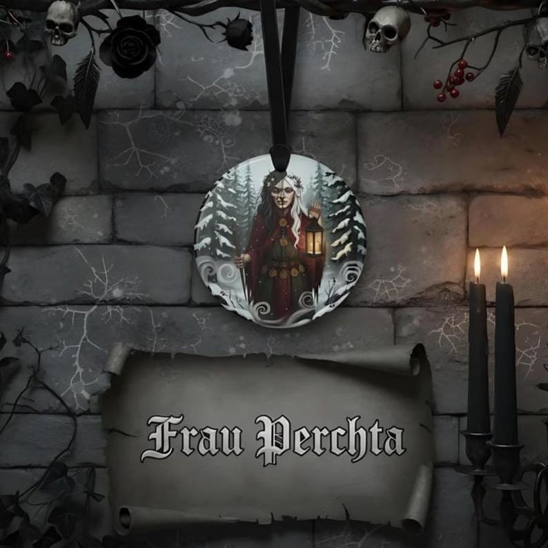 May include: A circular hanging ornament featuring an illustration of a figure in a dark red cloak holding a glowing lantern amidst a snowy forest. Below the ornament is a scroll-shaped sign with the text Frau Perchta written in black gothic font.