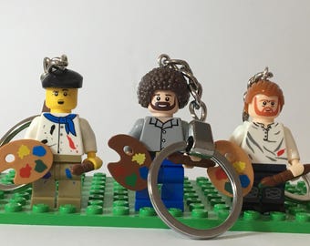 Individuell gestalteter Minifiguren-Schlüsselanhänger mit Geschenktüte – zur Auswahl stehen Schlüsselanhänger mit Ross Picasso und Van Gogh.