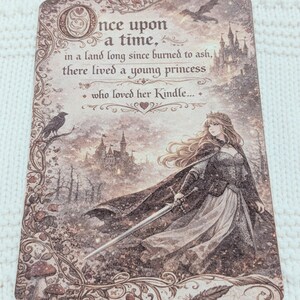 May include: A decorative card with a fantasy theme. The text reads "Once upon a time...there lived a young princess who loved her Kindle." The illustration shows a princess with a sword, a castle, a raven, and a flying creature.