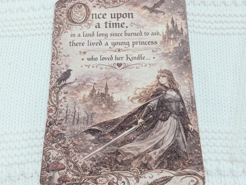 May include: A decorative card with a fantasy theme. The text reads "Once upon a time...there lived a young princess who loved her Kindle." The illustration shows a princess with a sword, a castle, a raven, and a flying creature.