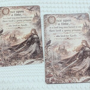 May include: Cards with a fantasy illustration of a princess holding a sword, a castle, and the text "Once upon a time." The cards have a vintage, sepia-toned aesthetic with decorative borders.