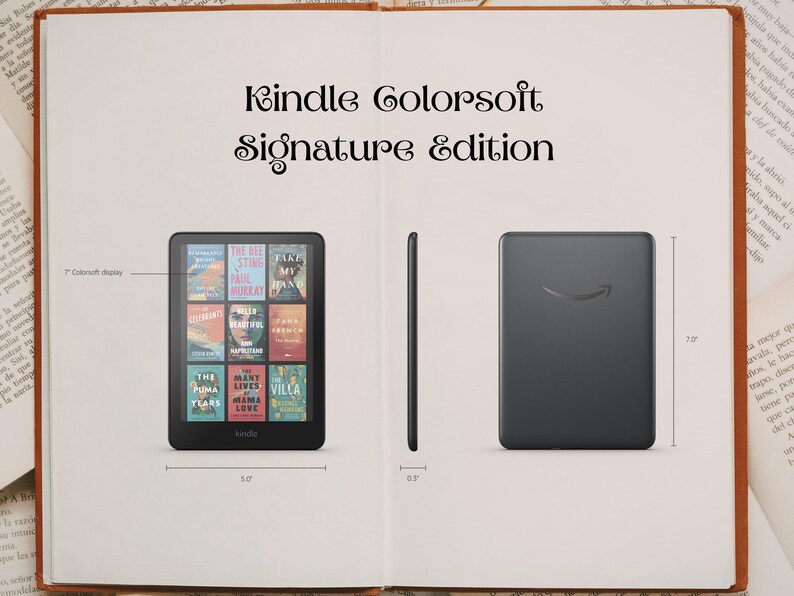 May include: A black Kindle Colorsoft Signature Edition e-reader, displayed open on a book. The screen shows book covers. The device is 15 cm wide and 18 cm tall. The back of the device has the Amazon logo.