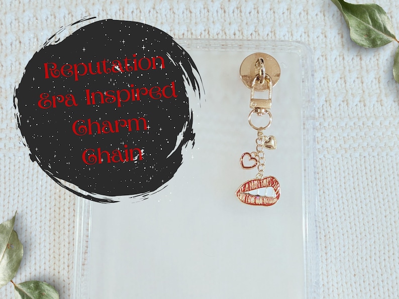 May include: A gold-toned charm chain with heart and lip charms. The charm is attached to a clear phone case. The text on the image says "Reputation Era Inspired Charm Chain."