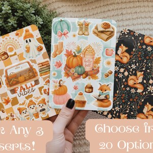 May include: Three rectangular paper inserts featuring autumn-themed illustrations. The left insert has a yellow checkered pattern with ghosts, pumpkins, and a truck. The centre insert shows pumpkins, a fox, and a coffee cup. The right insert has a black background with foxes and flowers.