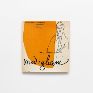 May include: A square book cover with an orange background and a black line drawing of a man. The title "modigliani" is written in cursive. The book's title includes the names Giovanni Scheiwiller and Amedeo Modigliani.