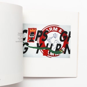 May include: A book page with a graphic design. The design includes the words "ARM & GRIPS" in black and red, a green snake, a figure with a crown, and a figure with a hammer. The image is on a white background.