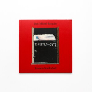 May include: A red book with the title "TO REPEL GHOSTS" on the cover. The cover features a black and white abstract painting with the artist's name, Jean-Michel Basquiat, at the top and "Kestner-Gesellschaft" at the bottom.