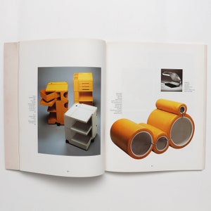 May include: A book open to two pages showing images of furniture. The left page shows a yellow and white modular shelving unit. The right page shows a yellow modular sofa with a headrest.