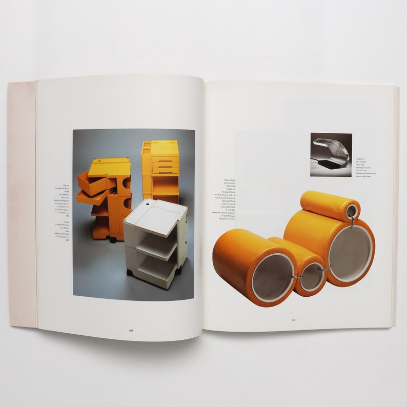 May include: A book open to two pages showing images of furniture. The left page shows a yellow and white modular shelving unit. The right page shows a yellow modular sofa with a headrest.