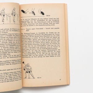 May include: Page from a book with illustrations and text about table tennis techniques. The page is tan with black text and diagrams. One diagram shows a player in action, while another shows a close-up of a player's hand and the ball.