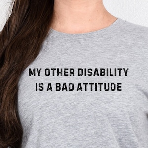 May include: Gray t-shirt with the text "My other disability is a bad attitude" printed in black.