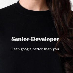 May include: Black t-shirt with white text that reads "Senior Developer I can google better than you."