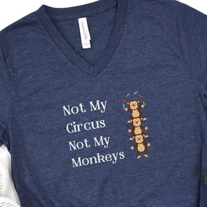 May include: A navy blue t-shirt with a white graphic of monkeys stacked on top of each other. The text "Not My Circus Not My Monkeys" is printed below the monkeys.