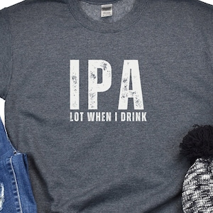 May include: A dark gray t-shirt with a white distressed graphic that says "IPA LOT WHEN I DRINK".