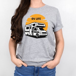 May include: A gray t-shirt with a graphic of a white RV in front of a yellow sun with the text "RV LIFE" above the RV.