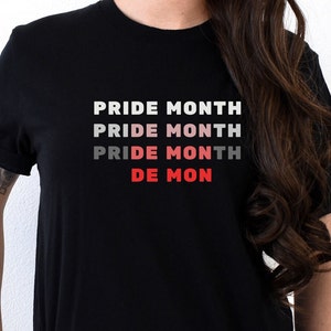 May include: Black t-shirt with the text "PRIDE MONTH" repeated in white, pink, and red, fading from white to red.