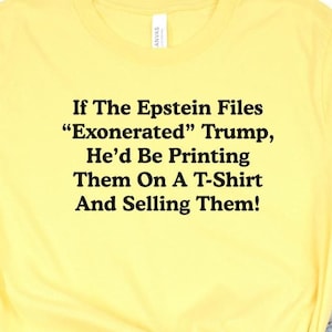 May include: Yellow t-shirt with black text: "If The Epstein Files 'Exonerated' Trump, He'd Be Printing Them On A T-Shirt And Selling Them!" The shirt has a crew neck and short sleeves.