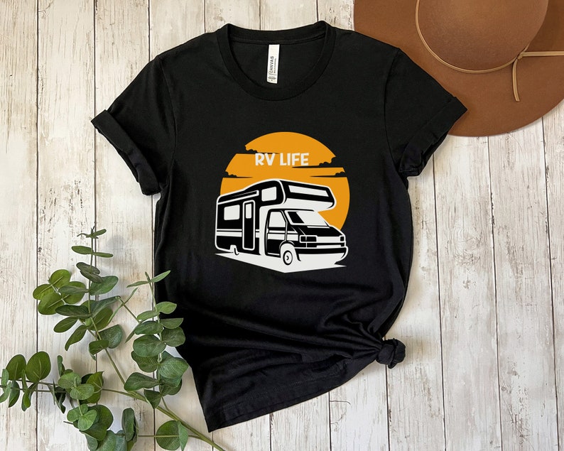 May include: Black t-shirt with a white graphic of an RV in front of a yellow sun with the text "RV LIFE" above it.