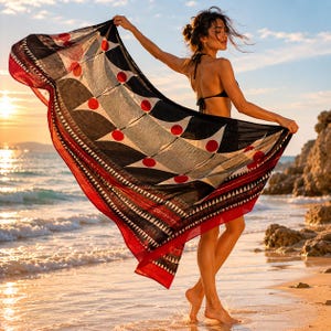 May include: A large rectangular sarong featuring a bold geometric pattern of black triangles and vibrant red circles. The fabric has a wide red border at the bottom edge decorated with a repeating white triangular motif and thin black horizontal lines.