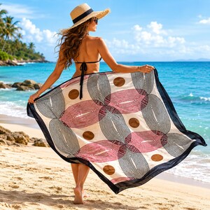 May include: A rectangular sarong featuring a cream-colored base with a repeating pattern of black and dark red concentric oval shapes and solid brown circles. The fabric is bordered by a solid black trim along the edges of the lightweight material.