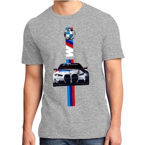 May include: Gray t-shirt featuring a BMW logo and a graphic of a BMW race car. The design includes the BMW logo, the word "BMW" in white, and vertical stripes in red, blue, and white.