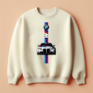 May include: A cream-coloured crewneck sweatshirt featuring a centred graphic of a white BMW car. Above the car is the BMW logo and the text BMW. A vertical stripe in blue, red, and white runs behind the car and logo, extending from the top to the bottom.