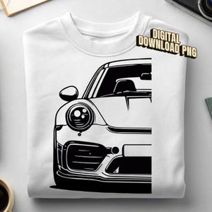 Może przedstawiać: Biały t-shirt z czarną grafiką przedstawiającą przednią połowę samochodu sportowego. Wzór zawiera okrągły reflektor, lusterko boczne i wlot powietrza w zderzaku. W prawym górnym rogu znajduje się nadruk z tekstem DIGITAL DOWNLOAD PNG.