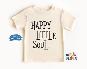 以下が含まれることがあります： 黒い文字で「HAPPY LITTLE SOUL」と書かれた、クリーム色の半袖Tシャツ。クルーネックで、柔らかい生地で作られている可能性が高いです。デザインはシンプルで、子供服に適しています。